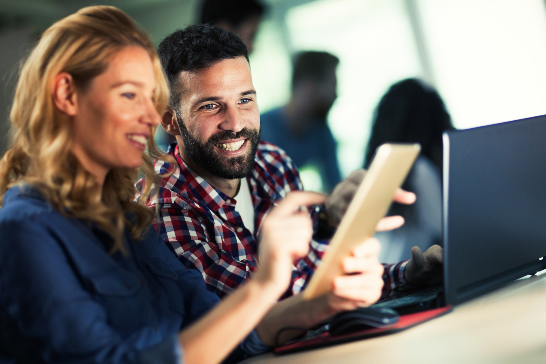 Smiling man and woman looking at a tablet together